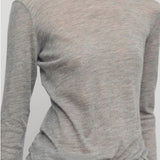 Front closeup view of grey melange iverness top on model wearing grey sweatpants, against a white background.