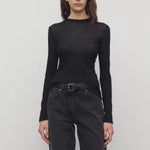 Front view of black iverness top on model wearing black jeans and belt against a white background.