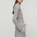 Side view of grey melange iverness top on model wearing grey sweatpants, against a white background.