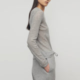 Side view of grey melange iverness top on model wearing grey sweatpants, against a white background.
