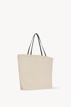Side slanted view of the ivory mesh and leather bag is pictured on a white background, with no model shown.