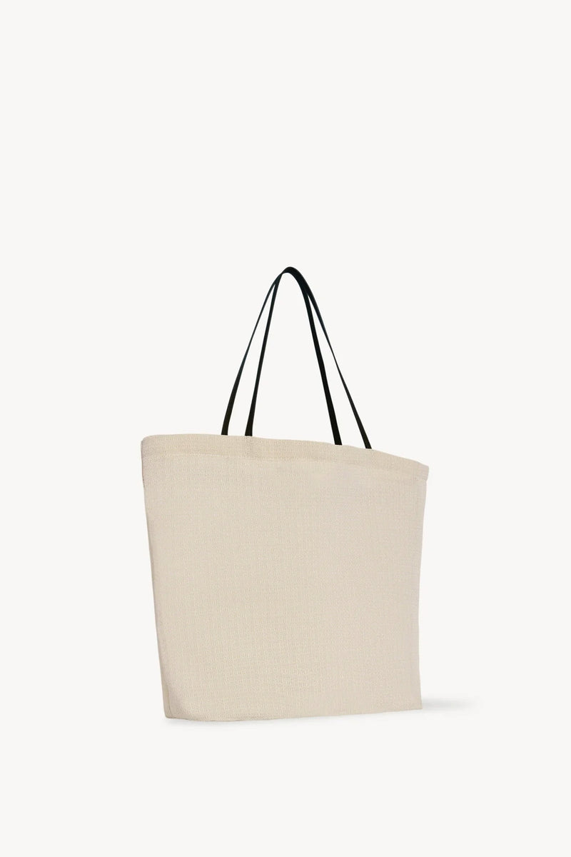 Side slanted view of the ivory mesh and leather bag is pictured on a white background, with no model shown.