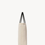 Side view of the ivory mesh and leather bag is pictured on a white background, with no model shown.