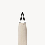 Side view of the ivory mesh and leather bag is pictured on a white background, with no model shown.