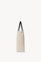 Side view of the ivory mesh and leather bag is pictured on a white background, with no model shown.