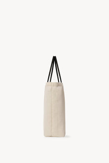 Side view of the ivory mesh and leather bag is pictured on a white background, with no model shown.