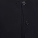 Front closeup view of black kala coat on model wearing black turtleneck, against a white background, 