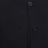 Front closeup view of black kala coat on model wearing black turtleneck, against a white background, 