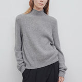 Front view of medium heather grey kensington top on model wearing black trousers, against a white background.