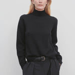 Front view of black kensington top on model wearing black trousers, against a white background.
