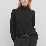 Front view of black kensington top on model wearing black trousers, against a white background.