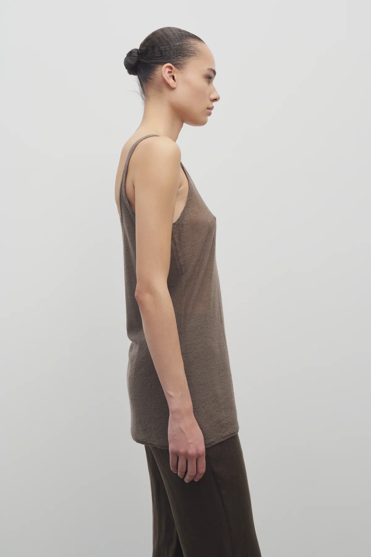 Side view of khaki kazu top on model wearing khaki pants, against a white background.