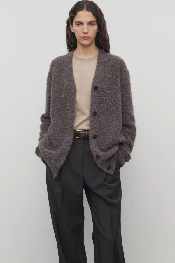 Front view of taupe laleh cardigan on model wearing beige top and charcoal pants, against a white background.