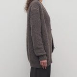 Side view of taupe laleh cardigan on model wearing charcoal pants, against a white background.