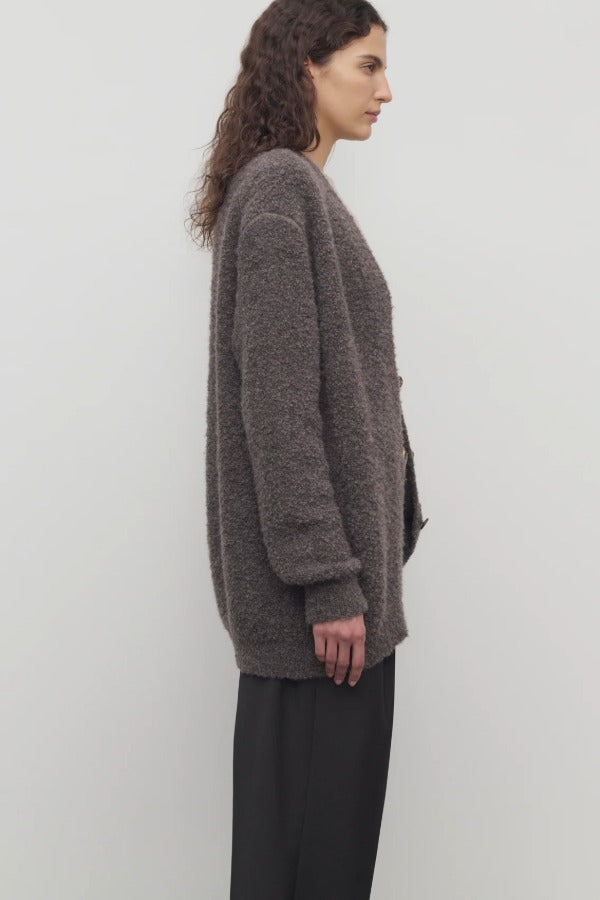 Side view of taupe laleh cardigan on model wearing charcoal pants, against a white background.