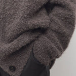 Front closeup view of taupe laleh cardigan on model wearing charcoal pants, against a white background.