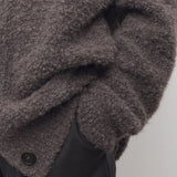 Front closeup view of taupe laleh cardigan on model wearing charcoal pants, against a white background.