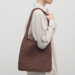 Front view of brown large didion bag on model wearing white striped dress, against a white background.