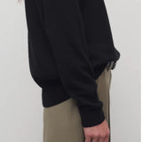 Side closeup view of black leilani top on model wearing khaki pants, against a white background.