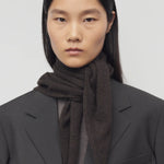 Front view of Brown Melange Leomine Scarf  on model wearing black coat, against a white background.