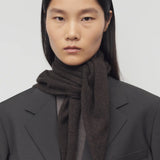 Front view of Brown Melange Leomine Scarf  on model wearing black coat, against a white background.