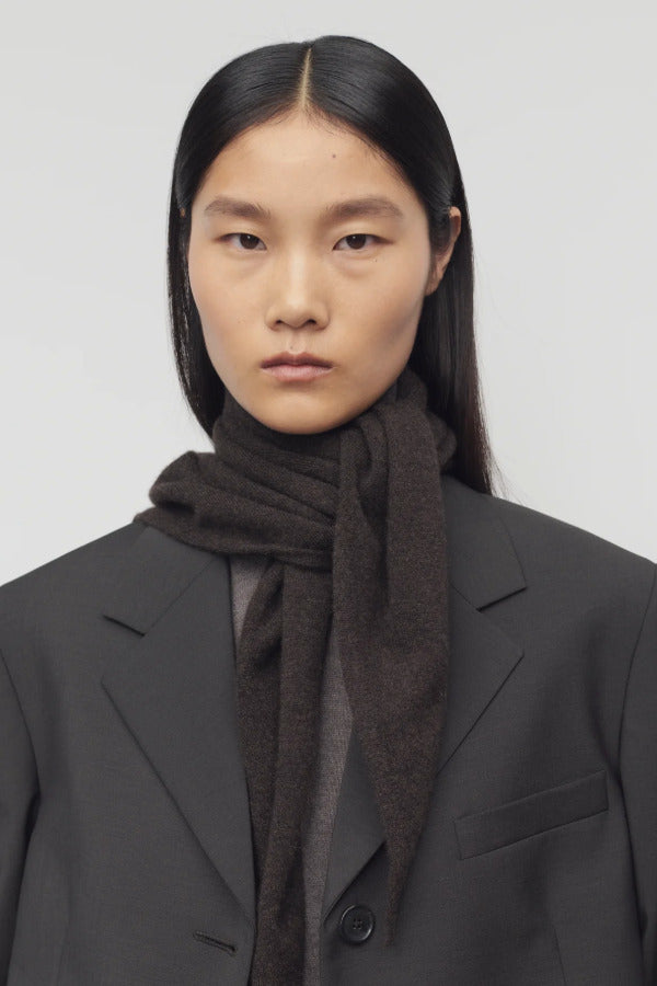 Front view of Brown Melange Leomine Scarf  on model wearing black coat, against a white background.