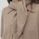 Front view of Taupe Leomine Scarf on model wearing Taupe sweater, against white background.