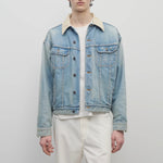 Front view of light indigo collared joret jacket on model wearing white trousers and white t-shirt, against a white background.