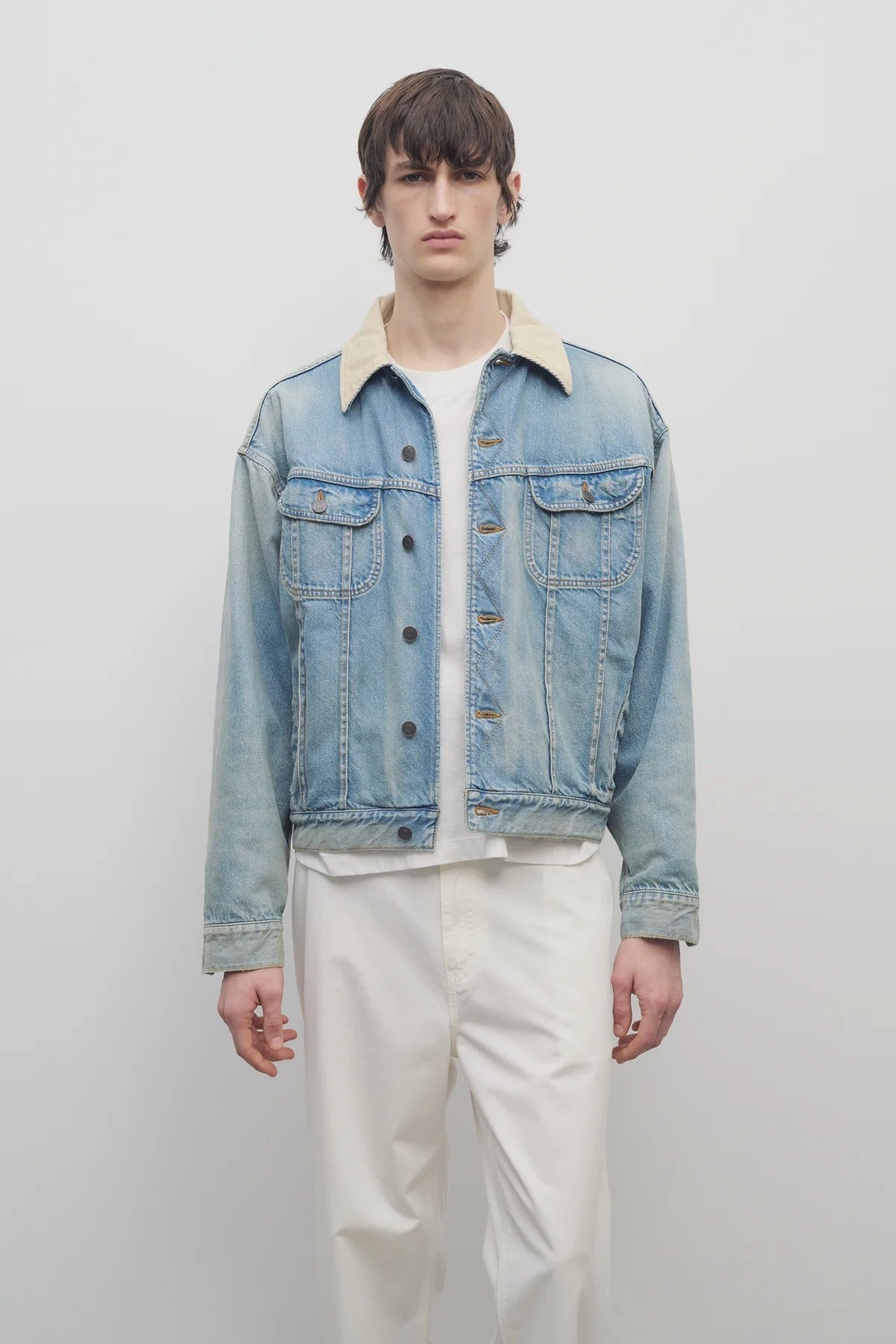 Front view of light indigo collared joret jacket on model wearing white trousers and white t-shirt, against a white background.