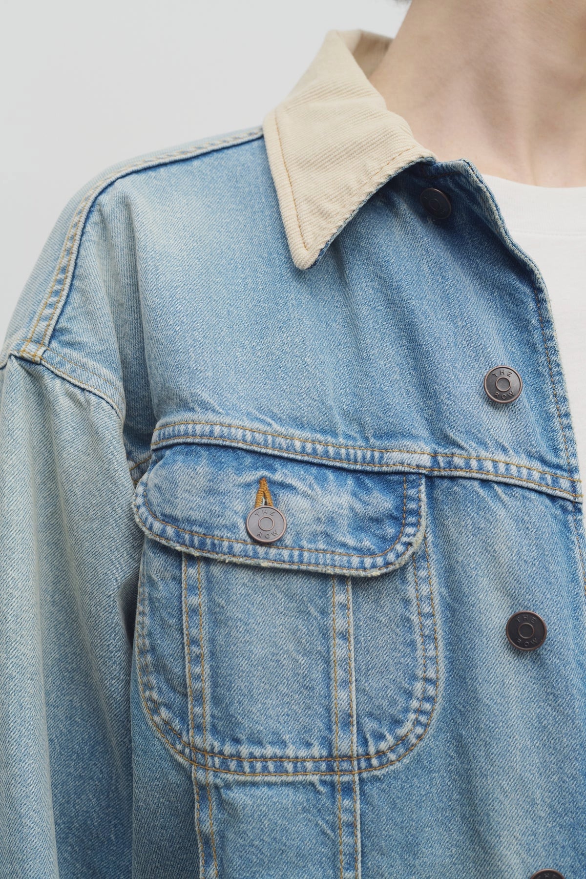 Front closeup view of light indigo collared joret jacket on model wearing white t-shirt, against a white background.