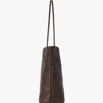 Side view of brown lilou woven tote on white background, with no model shown.
