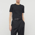 Front view of black linnea sweater on model wearing black pants and belt, against a white background.