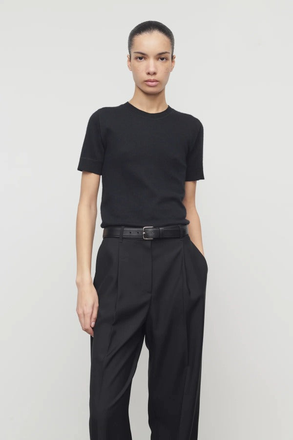 Front view of black linnea sweater on model wearing black pants and belt, against a white background.