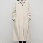 Front view of porcelain lolana coat on model wearing black oxfords, against a white background.