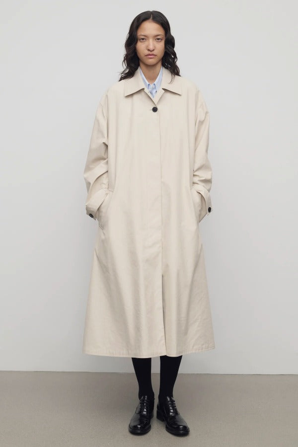 Front view of porcelain lolana coat on model wearing black oxfords, against a white background.