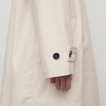 Side closeup view of porcelain lolana coat on model, against a white background.