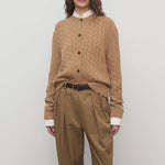 Front view of fawn loneke cardigan on model wearing camel pants, against a white background.