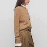 Side view of fawn loneke cardigan on model wearing camel pants, against a white background.