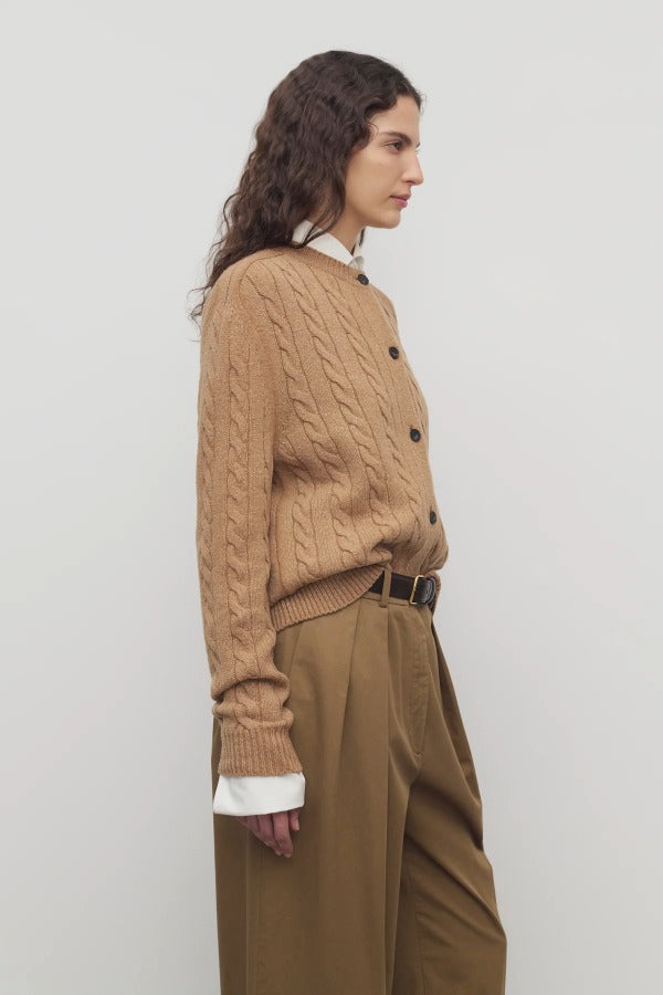 Side view of fawn loneke cardigan on model wearing camel pants, against a white background.