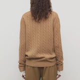 Back view of fawn loneke caridgan on model wearing camel pants, against a white background.