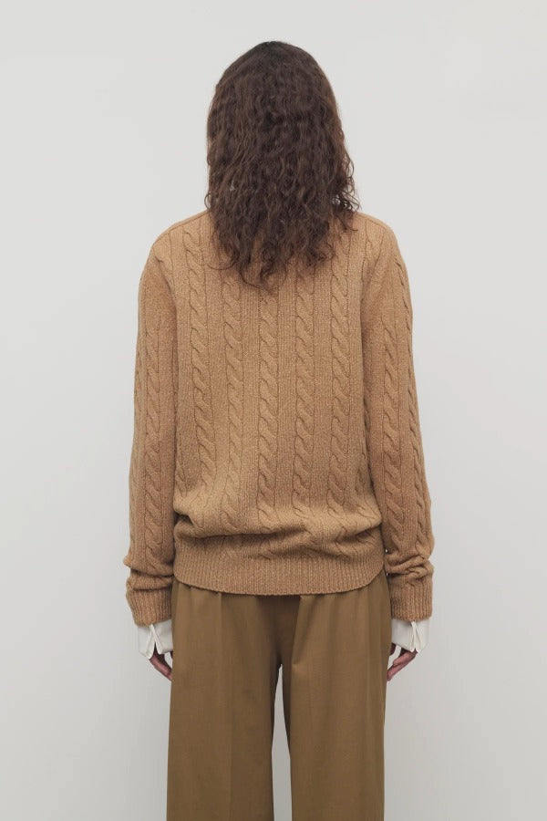 Back view of fawn loneke caridgan on model wearing camel pants, against a white background.
