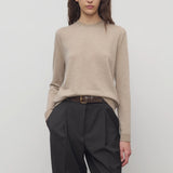 Front view of beige melange lorelei sweater on model wearing black pants and brown belt, against a white background.