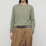 Front view of sage loynna top on model wearing camel trousers and brown belt, against a white background.
