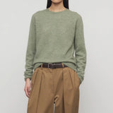 Front view of sage loynna top on model wearing camel trousers and brown belt, against a white background.