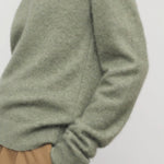 Side closeup view of sage lorynna top on model wearing camel trousers, against a white background.