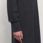Side closeup view of enzyme black loter dress on model, against a white background.