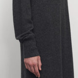 Side closeup view of enzyme black loter dress on model, against a white background.