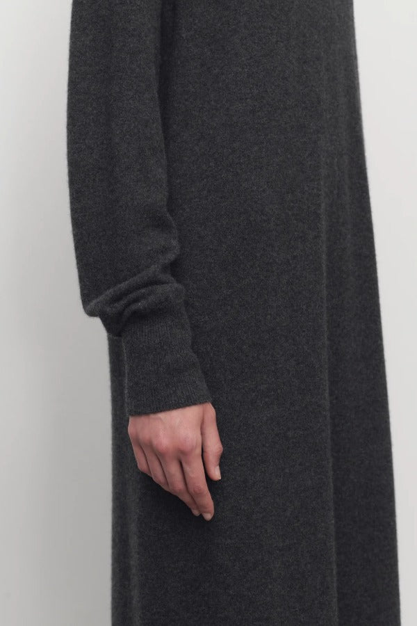 Side closeup view of enzyme black loter dress on model, against a white background.