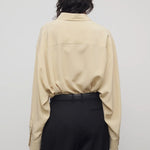 Back view of butter luka shirt on model wearing black pants, against a white background.