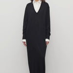 Front view of black luza dress on model wearing white collar shirt and black wedges, against a white background.